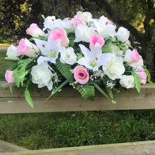 A top table flower arrangement of pink and ivory roses and lilies