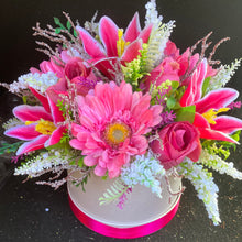 A flower arrangement in cream hat box