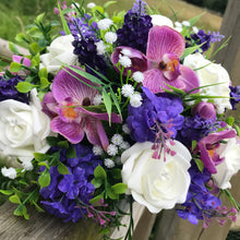 a flower arrangement of mauve & ivory roses, orchids and foliage