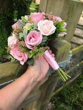 A bridal bouquet collection of dusky pink artificial silk roses and foliage