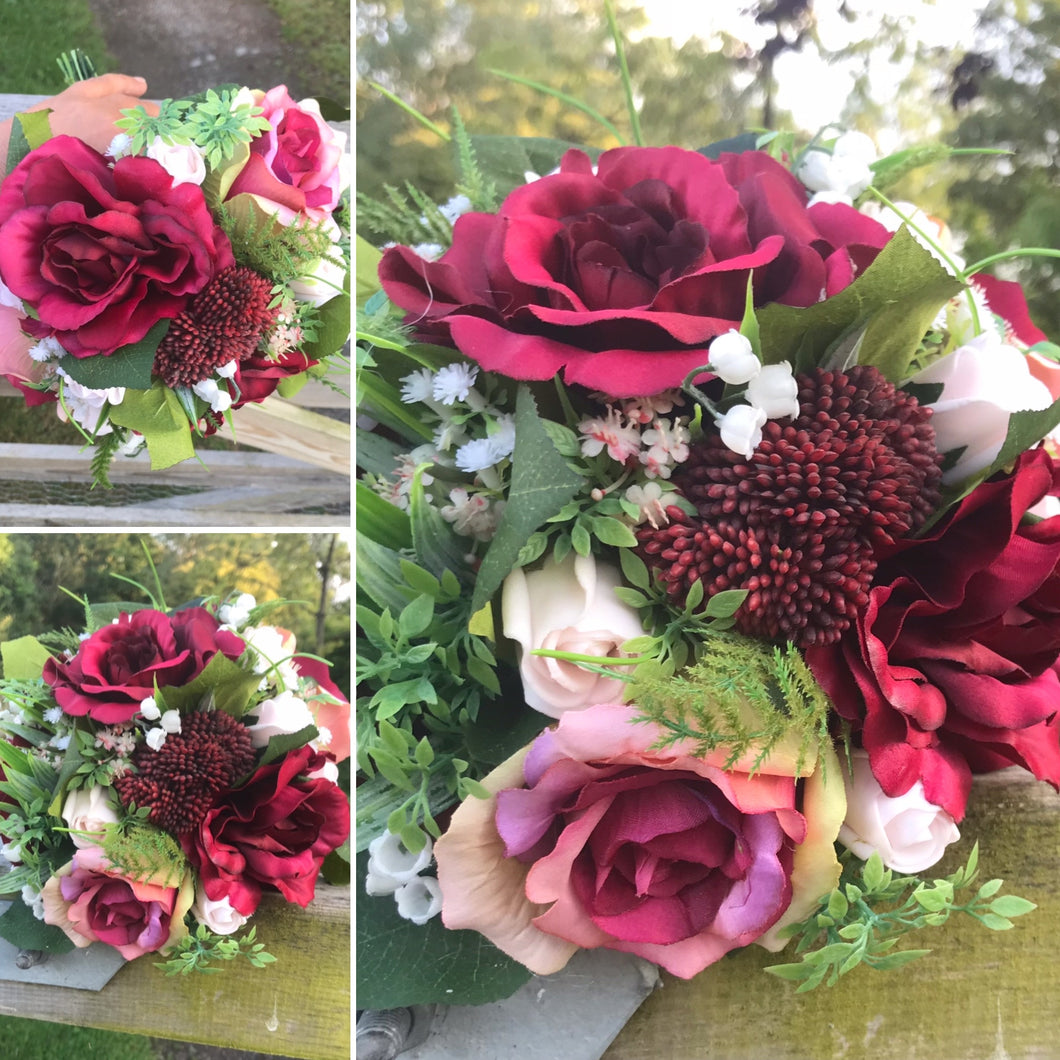A wedding bouquet of artificial burgundy and pink roses