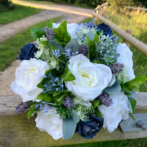 A wedding bouquet of navy blue and ivory flowers