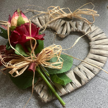 a rustic heart shaped wreath decorated with dried flowers