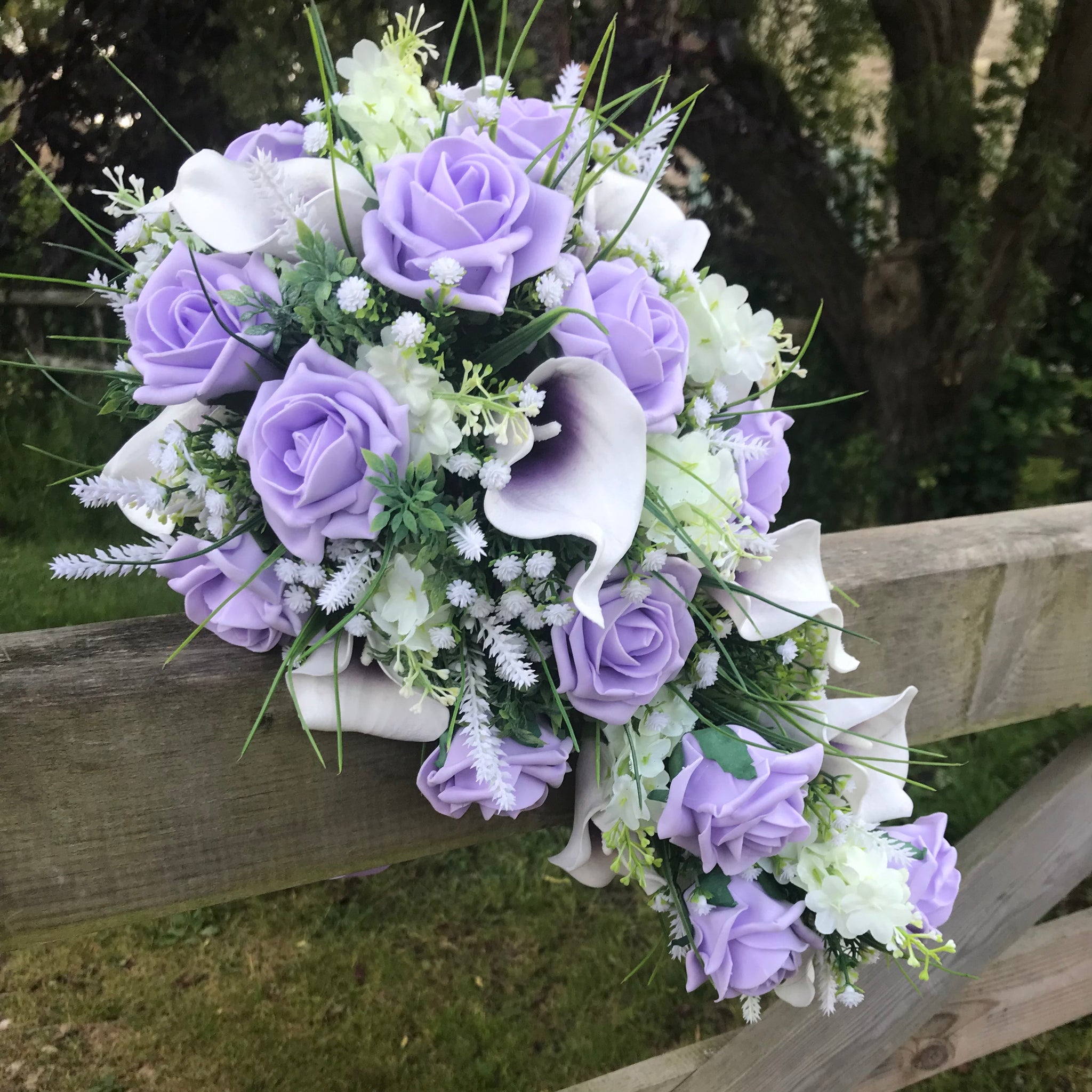 A wedding bouquet collection of lilac roses calla lilies