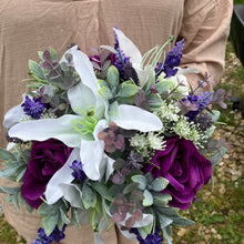 A wedding bouquet featuring purple & white flowers