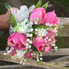 a brides wedding bouquet of artificial roses & lily of the valley