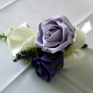 an artificial wedding corsage of ivory & purple foam roses plus calla lily