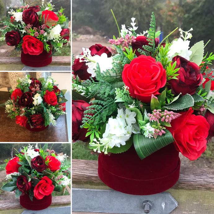 artificial red and burgundy flowers in hat box