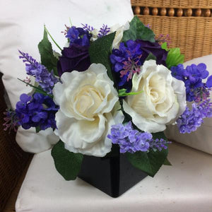 a table arrangement of lilac ivory and purple flowers