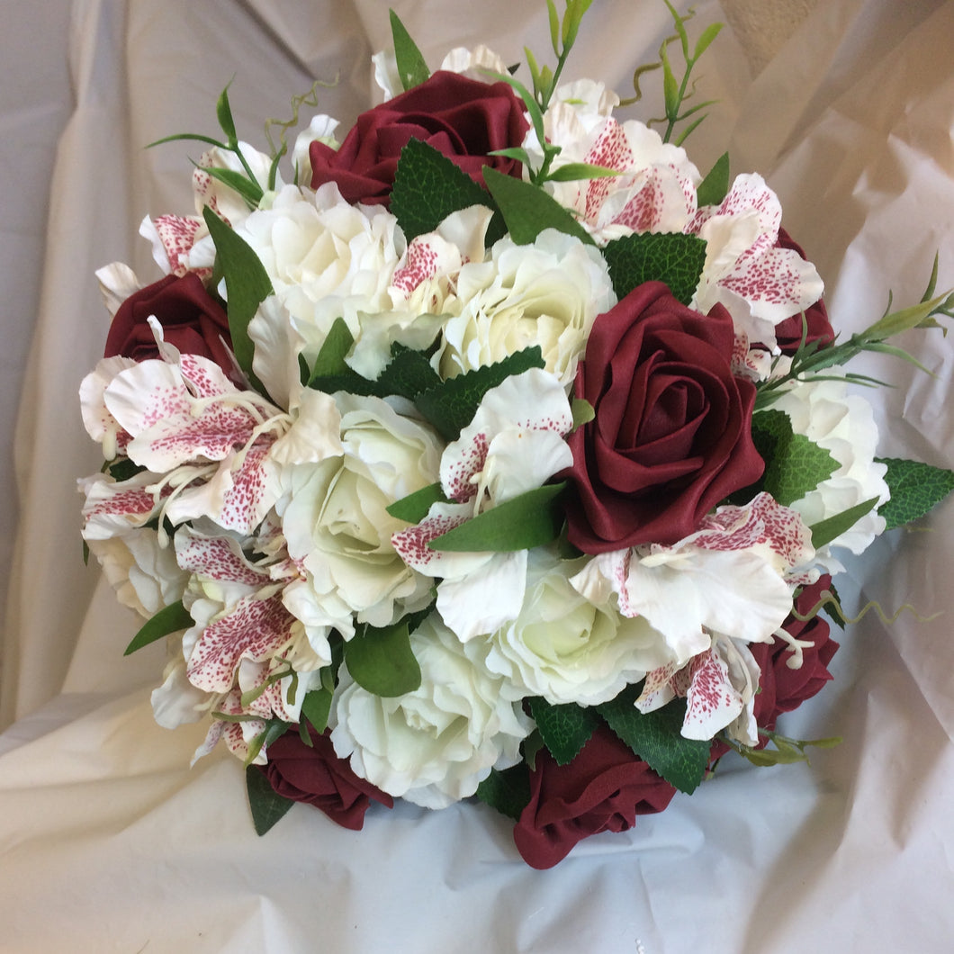 A WEDDING BOUQUET OF BURGUNDY AND IVORY ROSES