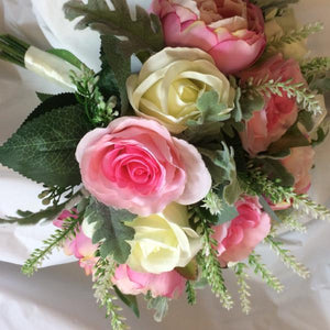 A brides bouquet of pink artificial silk rose flowers
