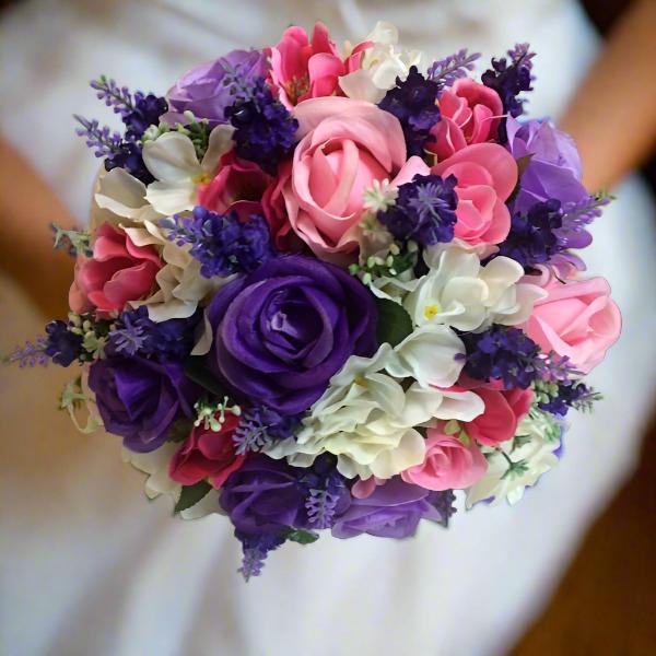 A brides wedding bouquet of artificial pink & purple flowers