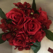 A bridesmaid bouquet or red artificial silk roses and hydrangea