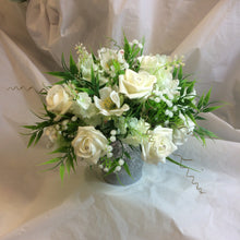 A table centre featuring artificial ivory flowers