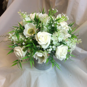 A table centre featuring artificial ivory flowers