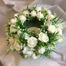 A table centrepiece of ivory flowers and foliage