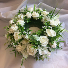 A table centrepiece of ivory flowers and foliage