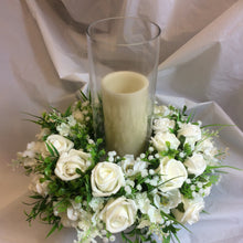 A table centrepiece of ivory flowers and foliage