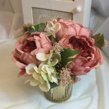 silk flower arrangement in gold glass container