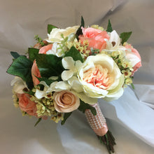A brides bouquet featuring peach silk roses, hydrangea & lilies
