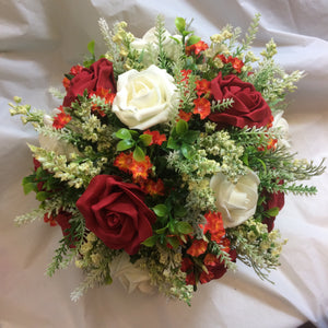 A flower arrangement of ivory orange and red flowers