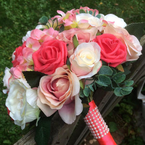 a brides bouquet of artificial coral and apricot flowers