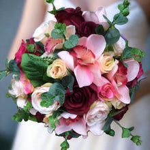 a wedding bouquet of coral and burgundy silk flowers