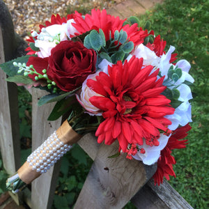 a brides wedding bouquet of artificial silk ivory, red & peach flowers