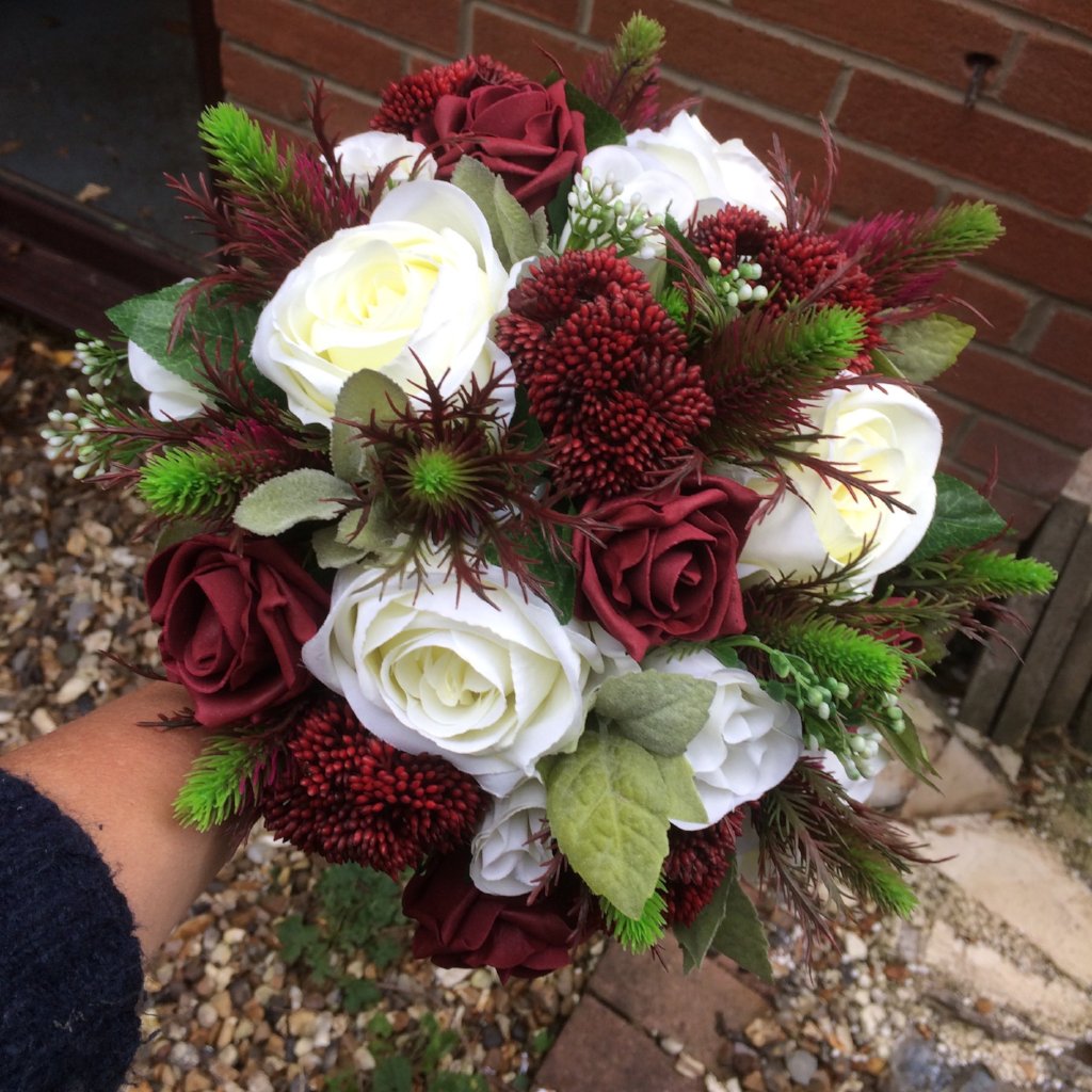 wedding bouquet of artificial flowers in shades of ivory and burgundy 