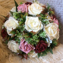 a wedding bouquet of burgundy ivory and pink foam roses, hypericum and hydrangea