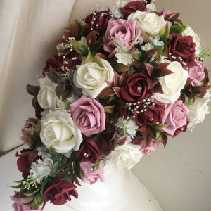 a teardrop bouquet of foam roses in shades of ivory burgundy and dusky pink