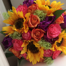 a brides bouquet of sunflowers roses, ranunculus and tulips