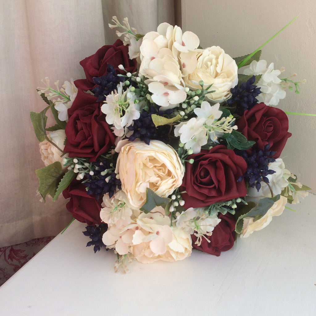 A wedding colllection of cream ranunculus, burgundy roses & berries ...