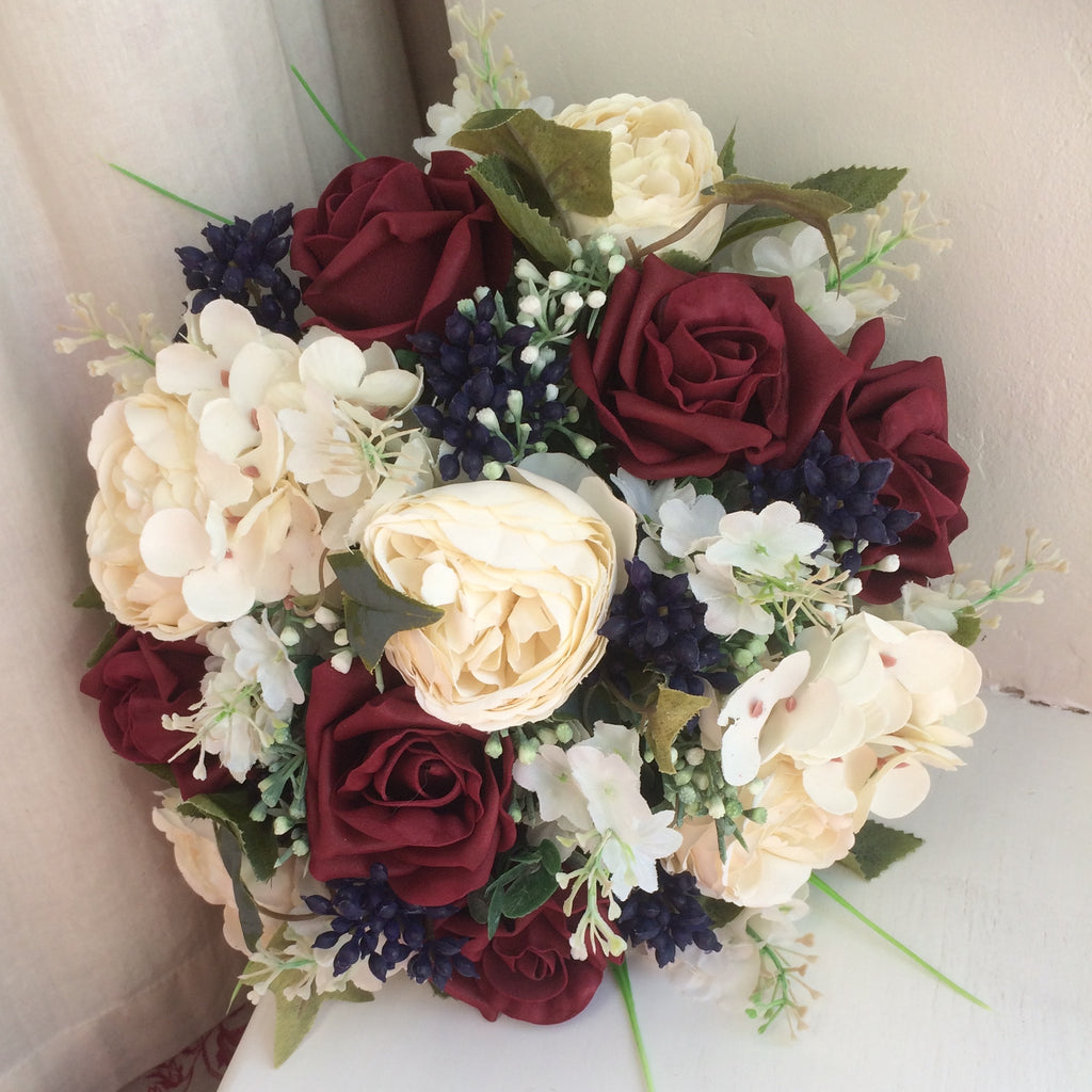 A wedding colllection of cream ranunculus, burgundy roses & berries ...