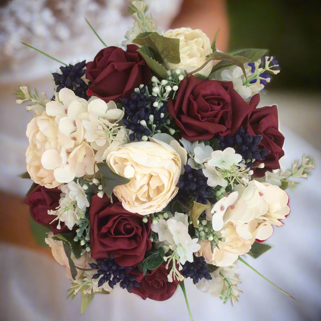 A wedding colllection of cream ranunculus, burgundy roses & berries