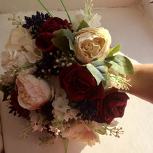 A wedding colllection of cream ranunculus, burgundy roses & berries