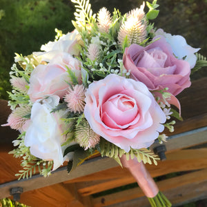 A bouquet collection of gypsophila and artificial pink roses, foliage and thistles