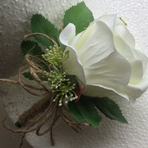 a buttonhole featuring lily of the valley & a white or ivory silk rose