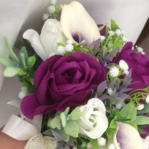 A wedding bouquet of purple and ivory silk flowers