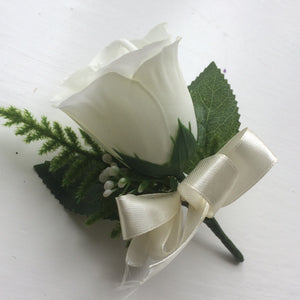 wedding buttonhole features a single white or ivory rose with asparagus fern
