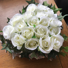 A flower arrangement of ivory roses arranged in a heart shape