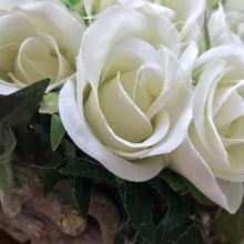 A flower arrangement of ivory roses arranged in a heart shape