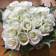 A flower arrangement of ivory roses arranged in a heart shape