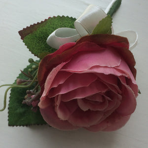 a silk buttonhole featuring pink rose and ivory bow