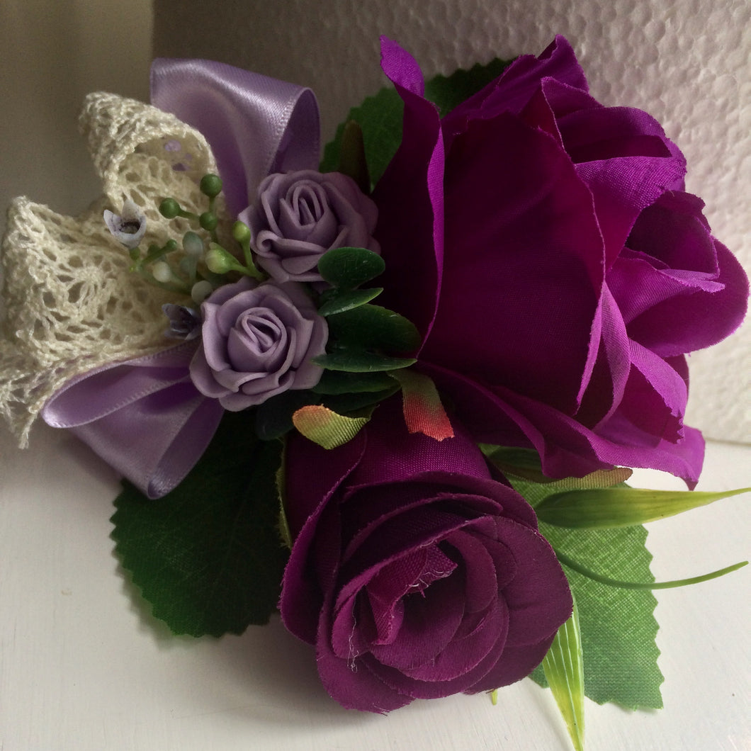 a corsage of purple and lilac roses