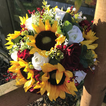 A wedding bouquet featuring berries, roses & sunflowers