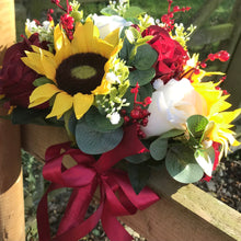 A wedding bouquet featuring berries, roses & sunflowers