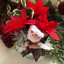 An artificial silk Christmas poinsettia and santa arranged in galvanized pot