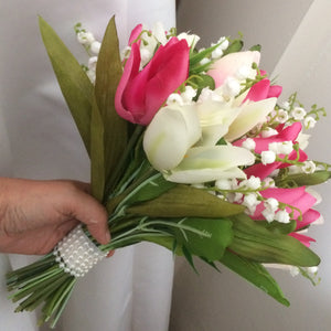 a wedding bouquet of pink and ivory tulips and lily of the valley