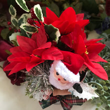 An artificial silk Christmas poinsettia and santa arranged in galvanized pot